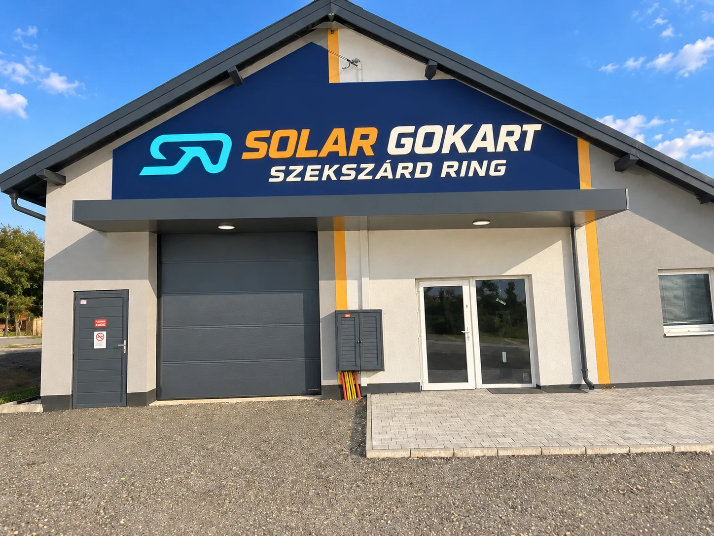 A főépület napfényes homlokzata jól olvasható Solar Gokart felirattal – nappali látványterv